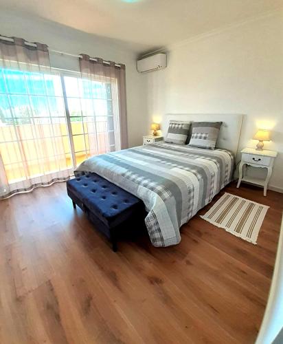 a bedroom with a bed and a large window at Algarve's Holiday Home with Sea View in Ferragudo