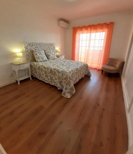 a bedroom with a bed and a wooden floor at Algarve's Holiday Home with Sea View in Ferragudo