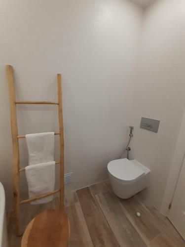 a bathroom with a toilet and a shelf with towels at Algarve's Holiday Home with Sea View in Ferragudo