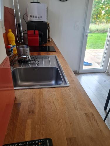 Il comprend une cuisine avec un évier en acier inoxydable et du parquet. dans l'établissement Studio indépendant à la campagne, proche Paray le Monial, à Volesvres
