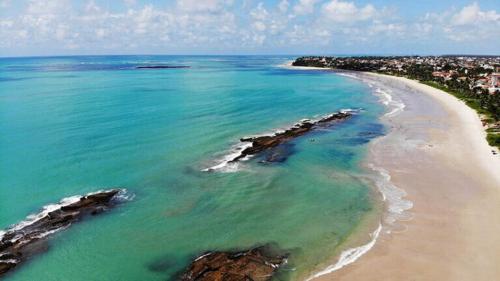 an aerial view of a beach with rocks in the water at Praia dos Carneiros Condomínio Village in Tamandaré
