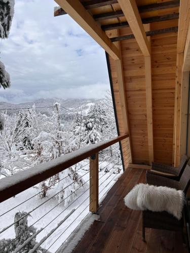 a room with a balcony with a view of snow covered trees at Molika Forest House in Kolašin