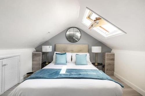 a bedroom with a large bed with blue pillows at Modern One Bedroom Duplex Apartment - Central Oxford in Oxford