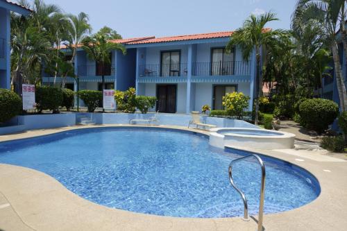 a swimming pool in front of a building at Pineapple Condo At Villa Riviera in Coco