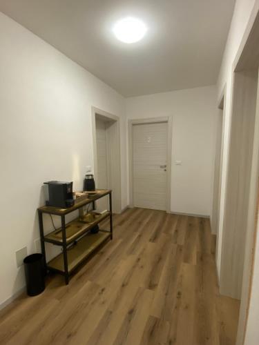 an empty living room with a wooden floor and a table at Colibrì Art B&B in San Martino in Argine