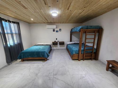 Un dormitorio con dos camas y techo de madera. en Hotel Bertis 2, en Creel
