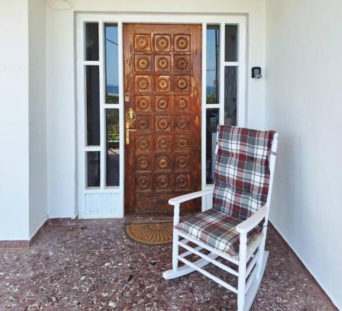 a rocking chair sitting in front of a door at Mare Nostrum in Koutsounari