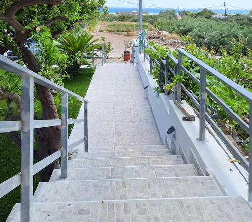 a staircase leading down to a beach with a fence at Mare Nostrum in Koutsounari