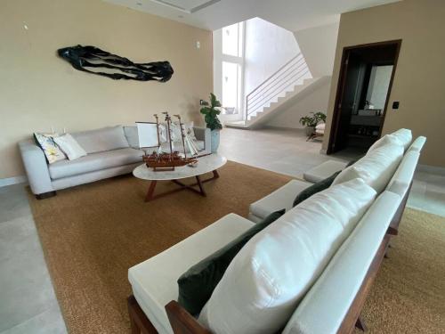 a living room with a couch and a table at Casa Luxuosa na Praia do Frances in Marechal Deodoro