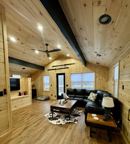 a living room with a black leather couch and a table at The Mont Haus - Minutes to Mt Snow & Stratton! in Wardsboro