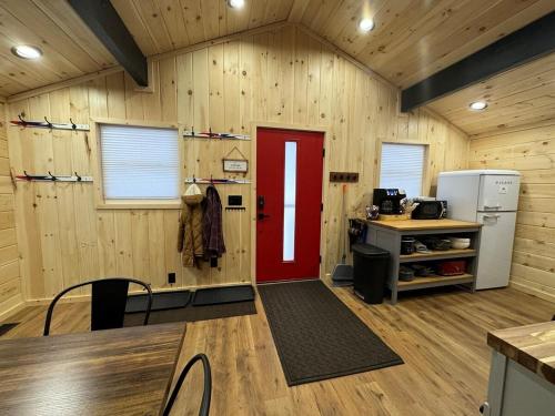a kitchen with a red door in a wooden wall at The Mont Haus - Minutes to Mt Snow & Stratton! in Wardsboro