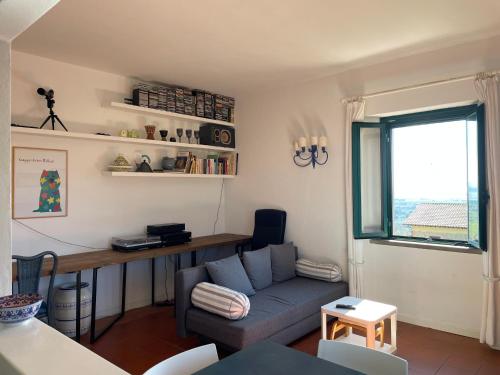 a living room with a couch and a desk at Antica Casa Prile in Castiglione della Pescaia