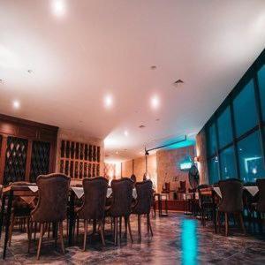 a dining room with chairs and tables in a building at Sunny escape Holiday apartment in İskele