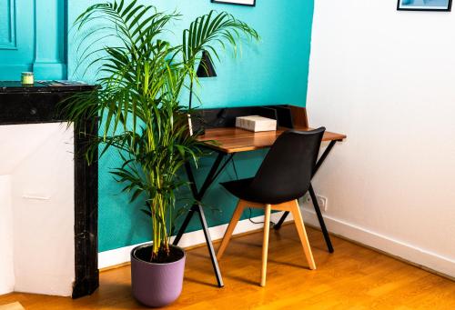 a desk with a chair and a plant in a room at T1 centre-ville refait à neuf in Brest
