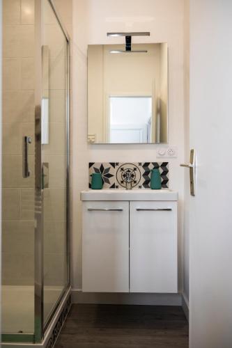 une salle de bain avec un lavabo et un miroir dans l'établissement T1 centre-ville refait à neuf, à Brest