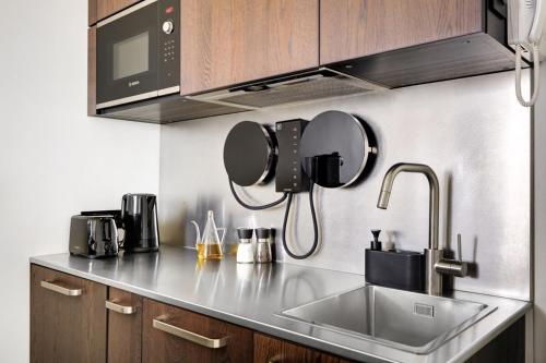 une cuisine avec un évier et un micro-ondes dans l'établissement La vie du marais, à Paris