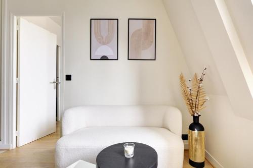 - un salon avec une chaise blanche et une table dans l'établissement La vie du marais, à Paris