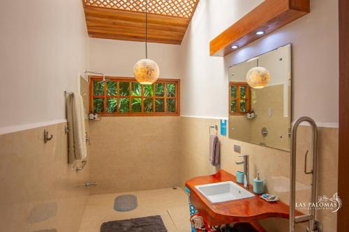 a bathroom with a sink and a mirror at Las Palomas Villas in Cocles