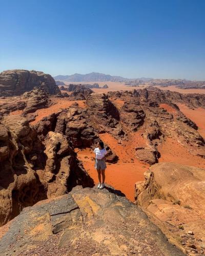 a person standing on a rock in the desert at Wadi Rum Wild Camp Desert in Wadi Rum