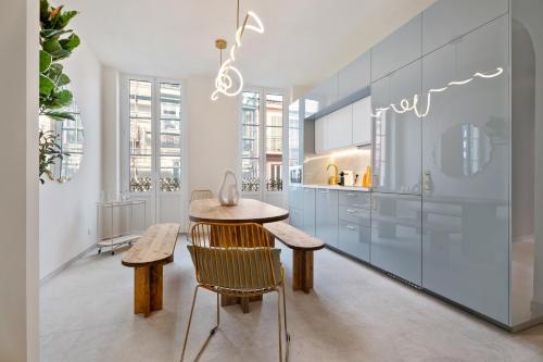 une cuisine avec une table et des chaises dans une pièce dans l'établissement Nice Renting - 8BONAPARTE - Architect Loft Luxury 4 Bedrooms View Place du Pin, à Nice