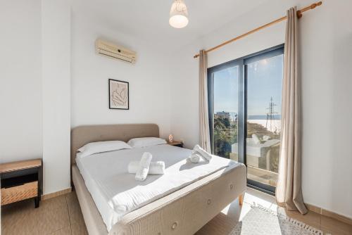 a bedroom with a bed and a large window at Exclusive Seafront Apartments Apartment 3 in Vlorë
