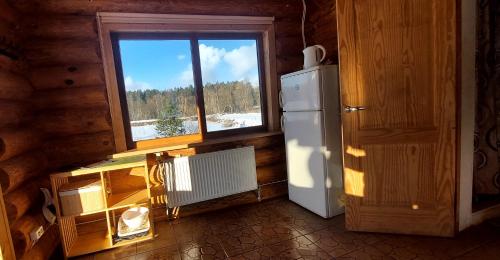 una cocina con nevera y ventana en Sauna&Relax, en Sakstagals