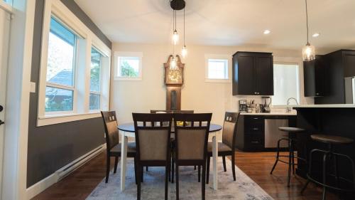 a kitchen and dining room with a table and chairs at Charming scape by Bear Mountain in Victoria
