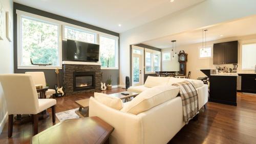 a living room with a white couch and a fireplace at Charming scape by Bear Mountain in Victoria