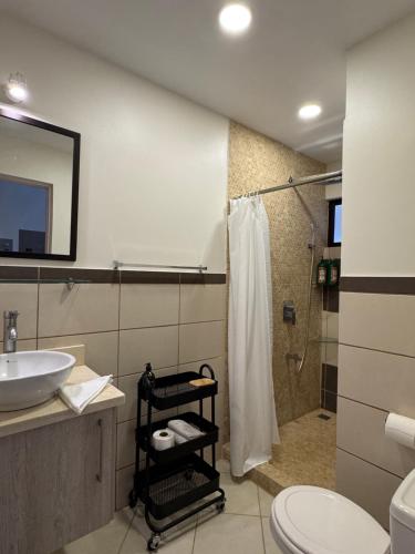 Un baño con lavabo, ducha e inodoro. en Sunscape Second Floor Condo With Rooftop, en Coco