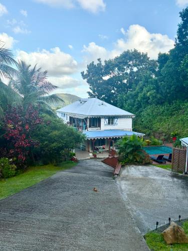 a large white house with a pool in front of it at Villa Mamalouken : App Léonie in Rivière-Pilote