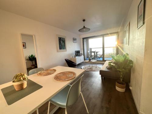 une chambre avec une table et des chaises ainsi qu'un salon dans l'établissement Les Deux Phares, à Les Sables-dʼOlonne