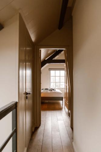 a hallway leading to a bedroom with a bed at CRASH'NSTAY - Wachtpost 20 in Waspik