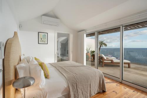 a white bedroom with a bed and a balcony at Casa Mar Dream House Old Town Funchal in Funchal
