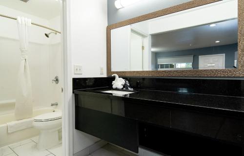 a bathroom with a black sink and a mirror at Colonial Palace Inn in Downey