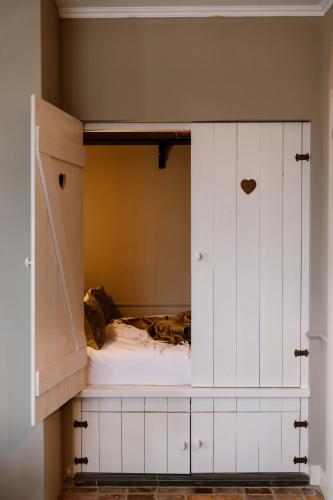 a white cabinet with a bed inside of it at CRASH'NSTAY - Wachtpost 22 in Nieuwe Vaart