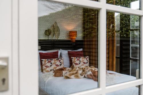 a bedroom with a bed with pillows and a window at CRASH'NSTAY - Wachtpost 22 in Nieuwe Vaart