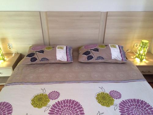 a bed with two pillows on top of it at Apartments Hrboka in Žman