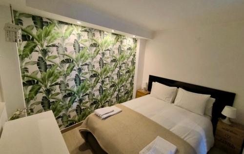 a bedroom with a bed and a curtain with plants at The Sun House in Santa Iria da Azóia