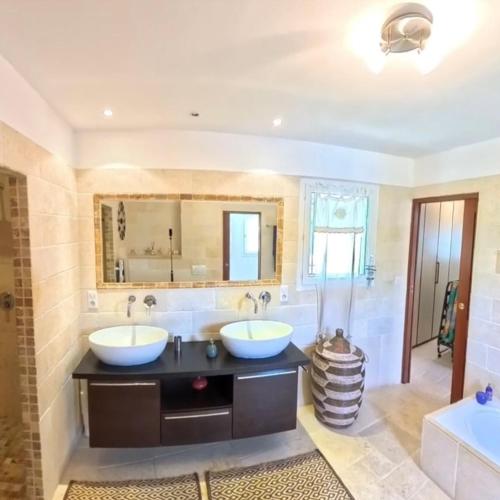 une salle de bain avec deux lavabos et un grand miroir dans l'établissement villa Peylon, à Flayosc