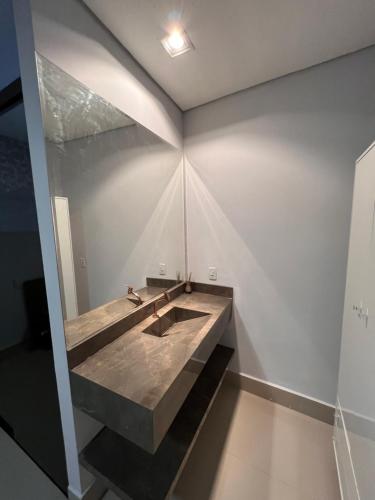 a bathroom with a sink in the middle of a wall at Suites Stival Centro in Goiânia