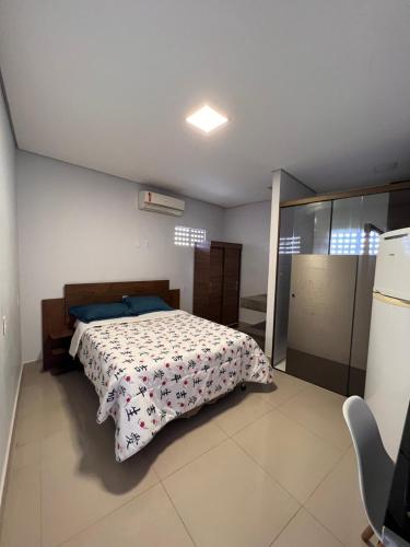 a bedroom with a bed with a comforter on it at Suites Stival Centro in Goiânia
