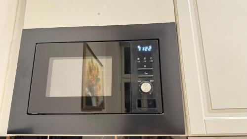 a black microwave oven with a picture on it at Newly renovated apartment in Wenceslas square in Prague