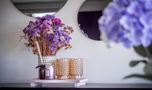 a vase of purple flowers sitting on a shelf at Mariri Heights Tasman in Upper Moutere