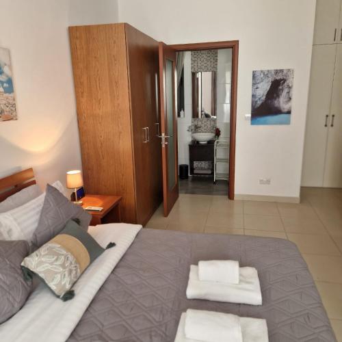 a bedroom with a bed with two towels on it at St Julians Cute Holiday Apartment with side seaview in St Julian's