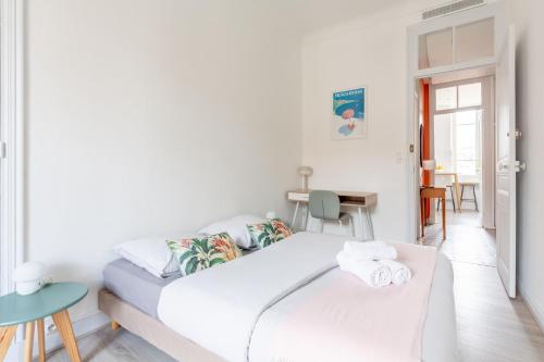 une chambre blanche avec un lit et une table dans l'établissement Appartement Retro-chic proche de la mer, 4 à 6 personnes, à Nice
