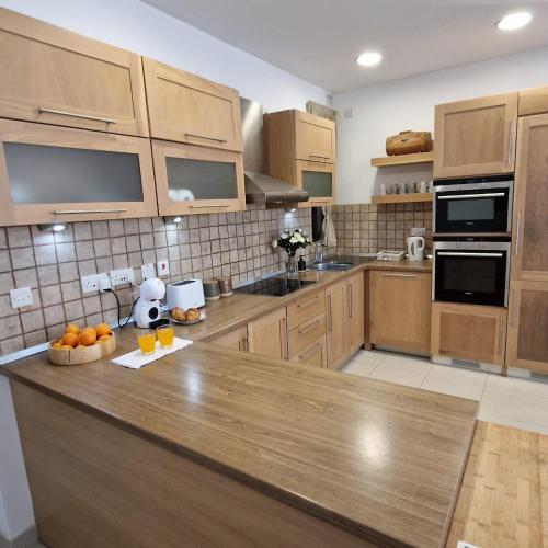 a kitchen with wooden cabinets and a wooden counter top at St Julians Cute Holiday Apartment with side seaview in St Julian's