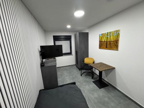 a room with a desk and a tv and a table at Modern Apartments Gelsenkirchen, nahe Schalke Arena, Zentral zur Autobahn A42 und A2, Ferienwohnung, Monteurwohnung in Gelsenkirchen