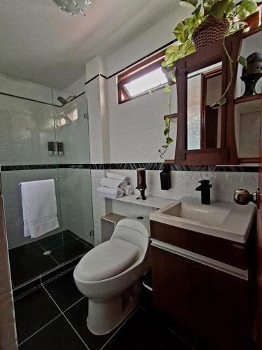 Un baño con inodoro, lavabo y ducha. en Casa Tobi, en Rionegro