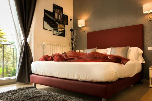 a bedroom with a large bed with a red blanket at Hotel Rossovino Como in Como