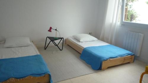 une chambre avec deux lits et une table et une fenêtre dans l'établissement La Marinette : holiday house Collioure centre, à Collioure